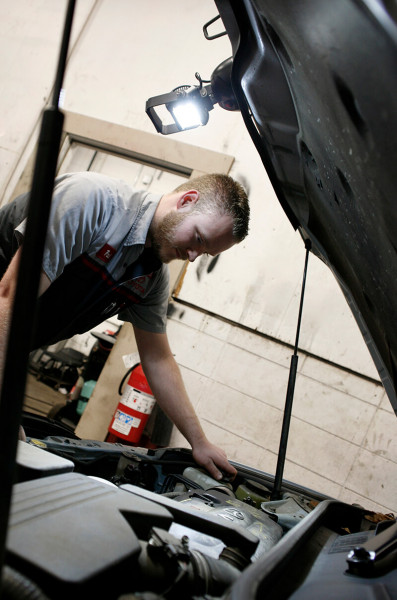 Mechanic using BriteZone LED work light to look under hood Mechanic using BriteZone LED work light to look under hood